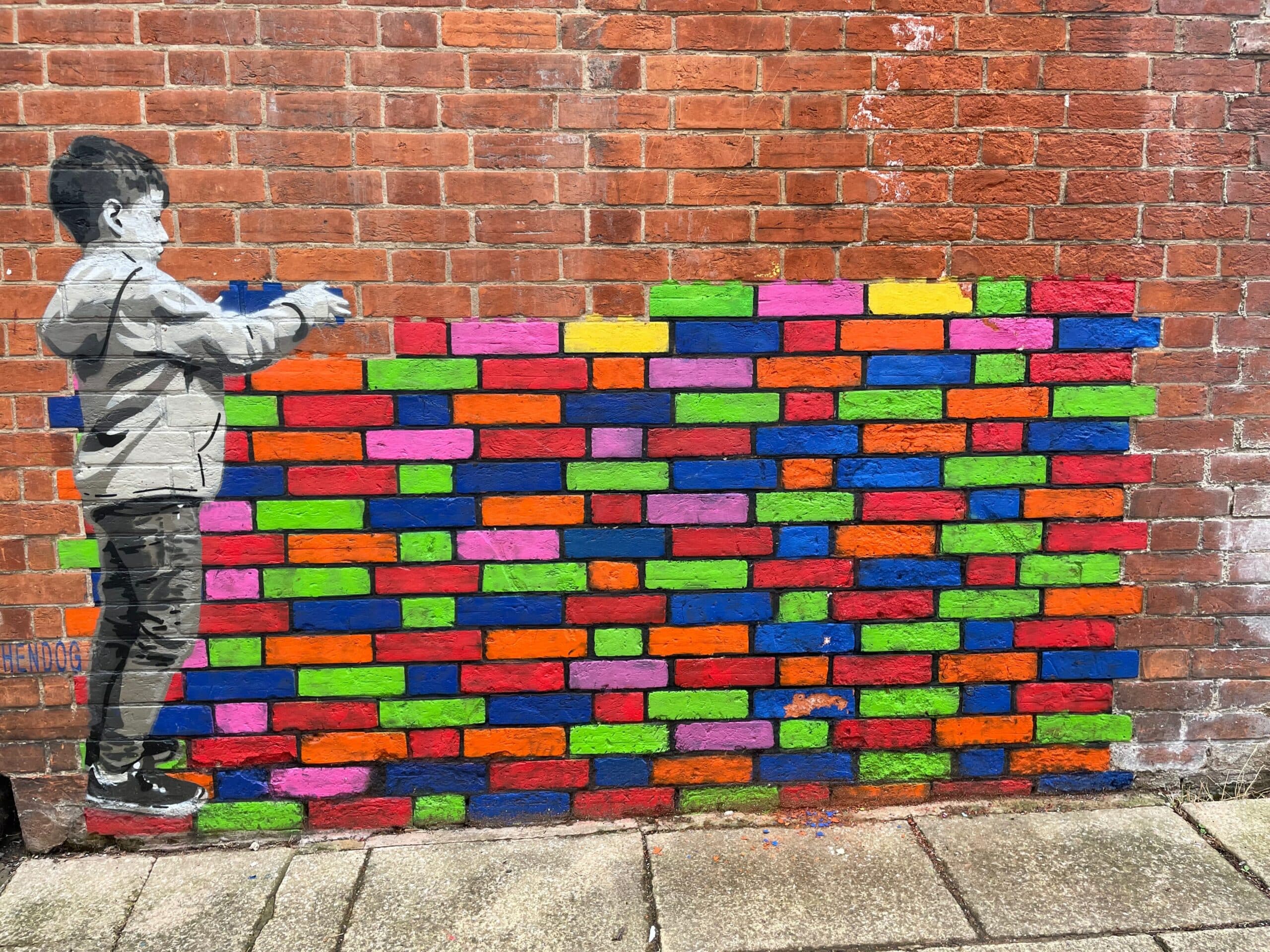 kid stacking bricks on a wall to represent stacking skills