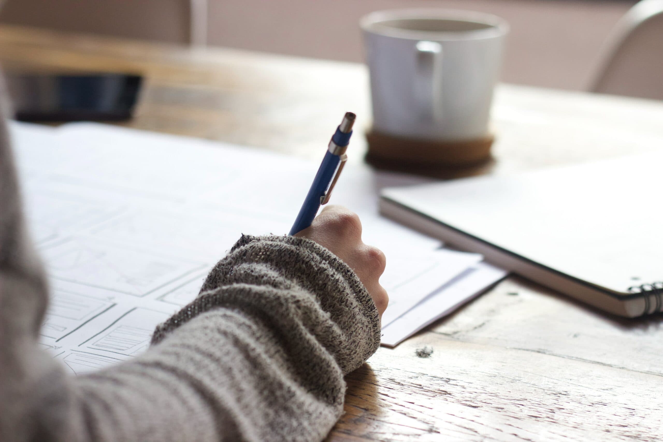 person writing essay on a desk